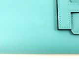 hermes logo on the front of a blue leather wallet