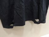 a black shirt hanging on a wall with a white background