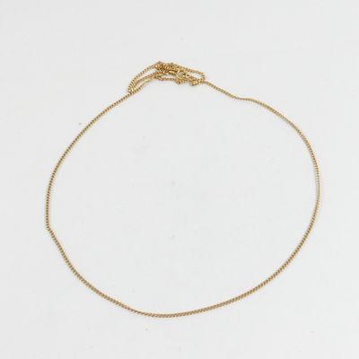 un bracelet à chaîne en or avec une breloque en forme de cœur sur fond blanc