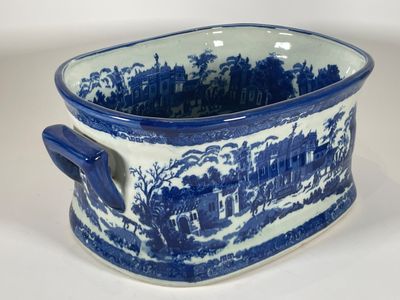 une tasse bleue et blanche sur laquelle est représentée une ville