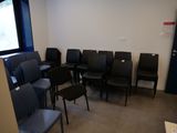 une pièce dans laquelle se trouvent plusieurs chaises noires