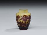 un vase jaune orné de fleurs, posé sur une table