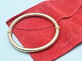 a red pouch with a gold bracelet on it