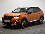 Le SUV orange est garé sur un sol à damier dans une pièce
