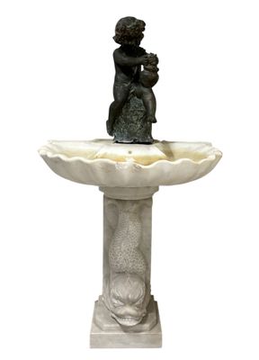 statue d'un garçon assis au sommet d'une fontaine sur laquelle se trouve un oiseau