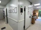 une photo d'un couloir dans un immeuble, avec des tableaux accrochés au mur