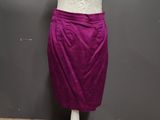 a white mannequine with a purple skirt on a wooden floor