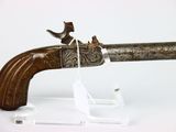 un fusil orné d'un oiseau, posé sur un socle transparent
