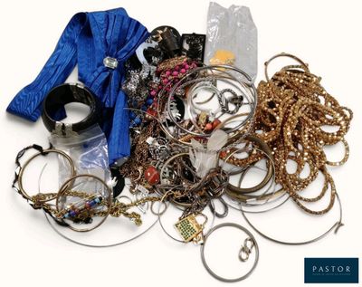 une pile de bijoux assortis sur une surface blanche