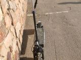 a scooter leaning against a stone wall in a parking lot