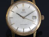 an image of a close up of a gold watch on a black surface
