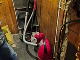 un homme debout dans une pièce, avec un sac rouge