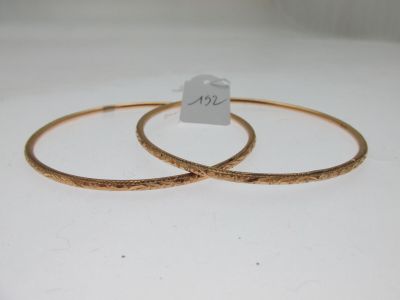 deux bracelets en or posés sur un fond blanc, avec une étiquette de prix