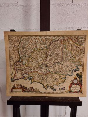 une vieille carte posée sur un support en bois, avec un mur de briques en arrière-plan