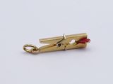 a close up of a small gold clip with a red bead on it