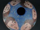 a blue vase with a picture of people on it