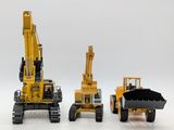 three construction vehicles that are lined up on a white surface