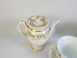 une théière et une tasse posées sur une table