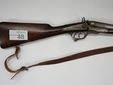 an old gun with a leather strap and a wooden handle