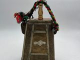 an old wooden bell with a rope around it on a white surface