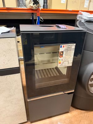 a small oven sitting on the floor next to other appliances