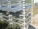 une clôture métallique à laquelle sont fixés plusieurs tuyaux