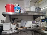 a metal shelf filled with pots and pans in a kitchen