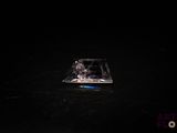 un petit morceau de verre posé sur une surface noire