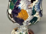 a white vase with a colorful floral design on it