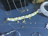 many different types of necklaces and bracelets laid out on a table