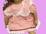 une poupée qui porte une robe rose et des chaussettes blanches