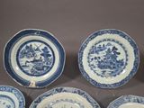 six blue and white plates with a picture of a village on them