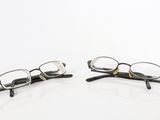two pairs of glasses sitting on a white surface
