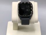 une montre connectée posée sur un socle, sur une table