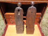 deux statues en bois qui se trouvent dans une boîte en bois