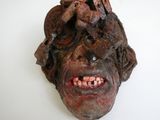 un gros plan sur une sculpture représentant une personne dont la tête est entièrement recouverte de dents