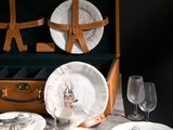 une valise sur laquelle est posé un service d'assiettes et de verres