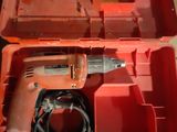 an orange tool box with a drill in it sitting on a table