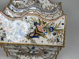 a white and gold plate with a flower design on it