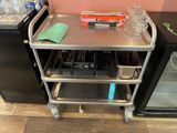 a small metal cart with a tray of food on it