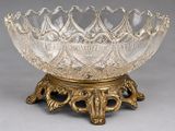 un bol en verre ancien posé sur un socle, sur une surface grise