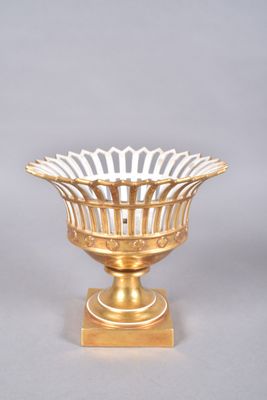 gold plated bowl on stand on grey background with white background