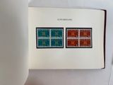 an open book with two stamps on it sitting on a table