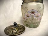 a glass jar with a lid next to a metal container