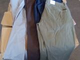 Plusieurs paires de pantalons sont empilées sur une palette dans un entrepôt