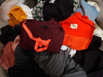 a pile of clothes sitting on top of a bed