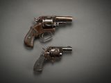 two old revolvers sitting on top of a table next to each other