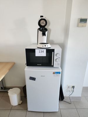 un micro-ondes posé sur un réfrigérateur dans une cuisine