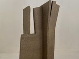 une sculpture en carton posée sur une surface blanche