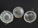 three glass dishes and a plate on a black background